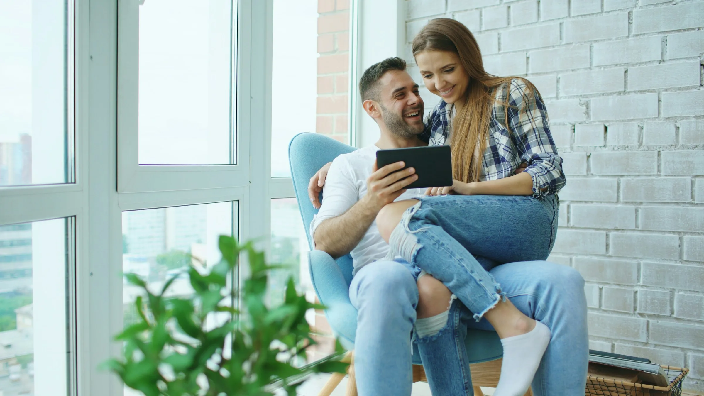 Couple sitting together and looking at a tablet