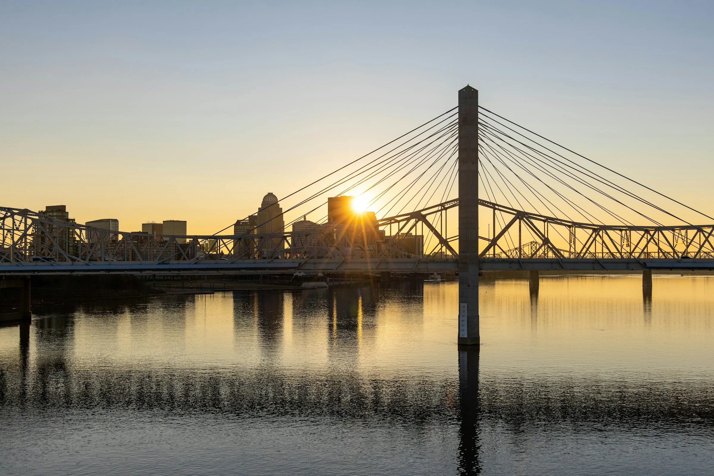 Louisville skyline and Ohio River bridge at sunset